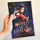 Shield of Shadow YA fantasy paperback in hand