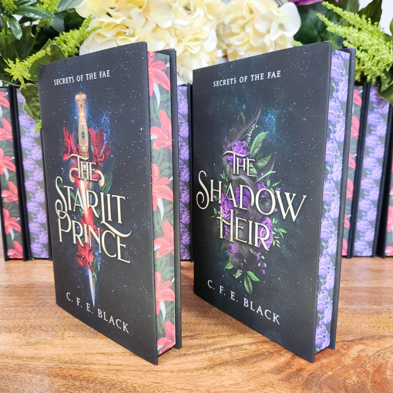 Two special edition fantasy romance books titled 'The Starlit Prince' and 'The Shadow Heir' by C.F.E Black with sprayed edges. 